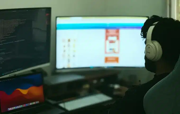 Engineer monitoring software across multiple displays, representing production controls for AI agents.