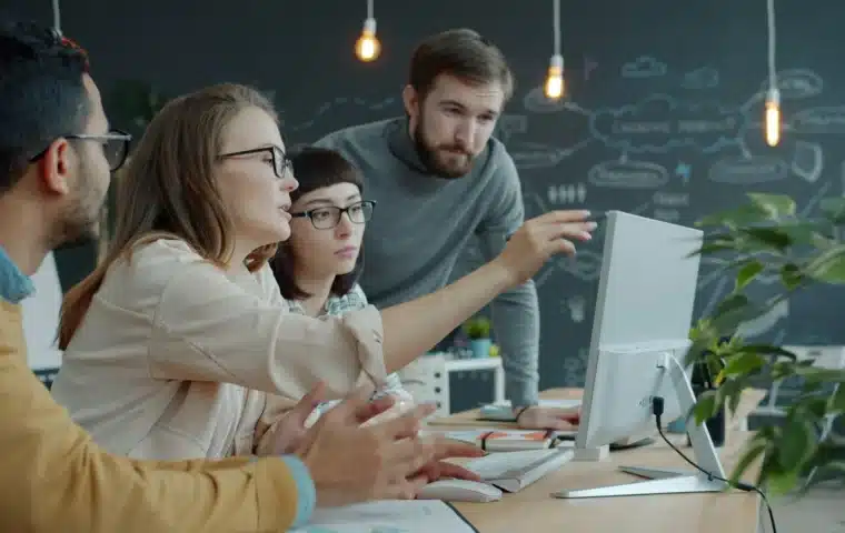 A technology team reviewing work together, representing operational governance for production AI.