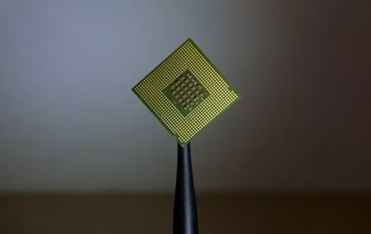 A computer processor held above a motherboard, representing production AI inference workloads.